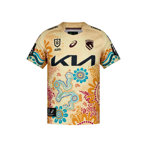 A short-sleeve rugby league kids jersey displayed flat against a white background. The jersey is cream-coloured with a vibrant Aboriginal-inspired dot art pattern in orange, blue, and pink, featuring a large black 'KIA' sponsor logo across the chest and various team and manufacturer logos.